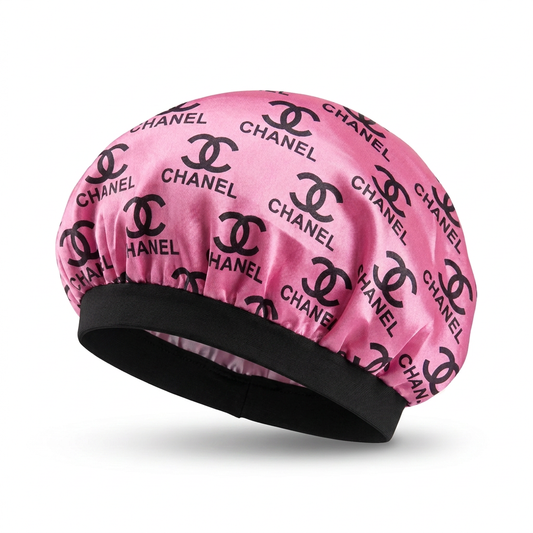 Pink bonnet with black print and a wide solid black headband on a white background