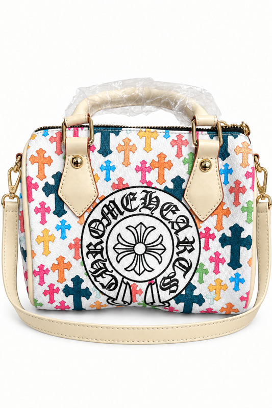 Digitally edited front view of colorful cross pillow bag with cream-colored shoulder strap on white background